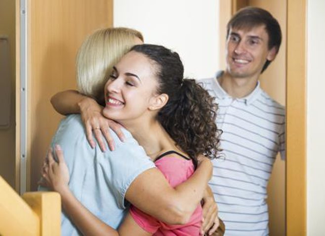 Family visiting and daughter hugging mom.