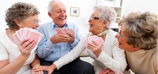 Adults playing card game and laughing.