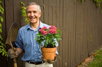 man with potted plant, gardening outdoors with mobile medical alert man with potted plant, gardening outdoors with mobile medical alert