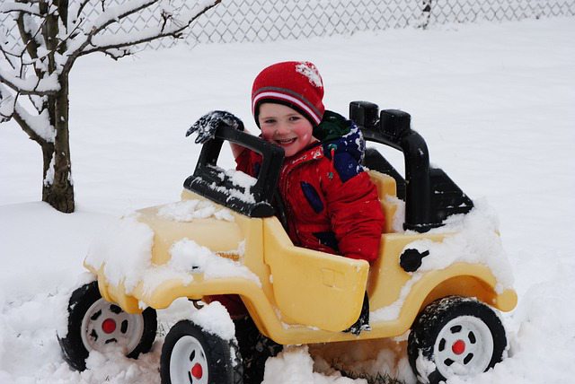 Child driving toy car in snow Child driving toy car in snow