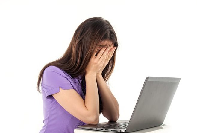 young caregiver frustrated in front of computer young caregiver frustrated in front of computer
