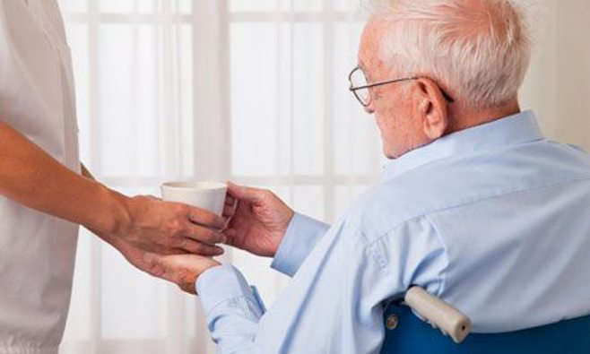 man in wheelchair handed water
